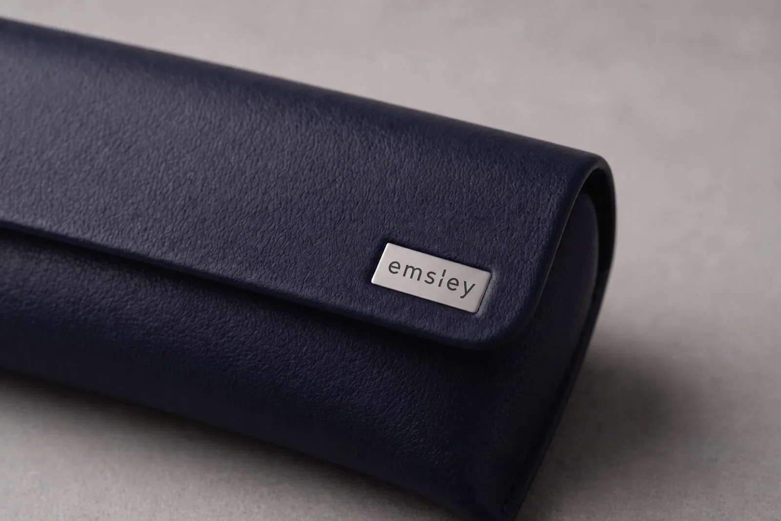 Navy leather fold case with metal badge.