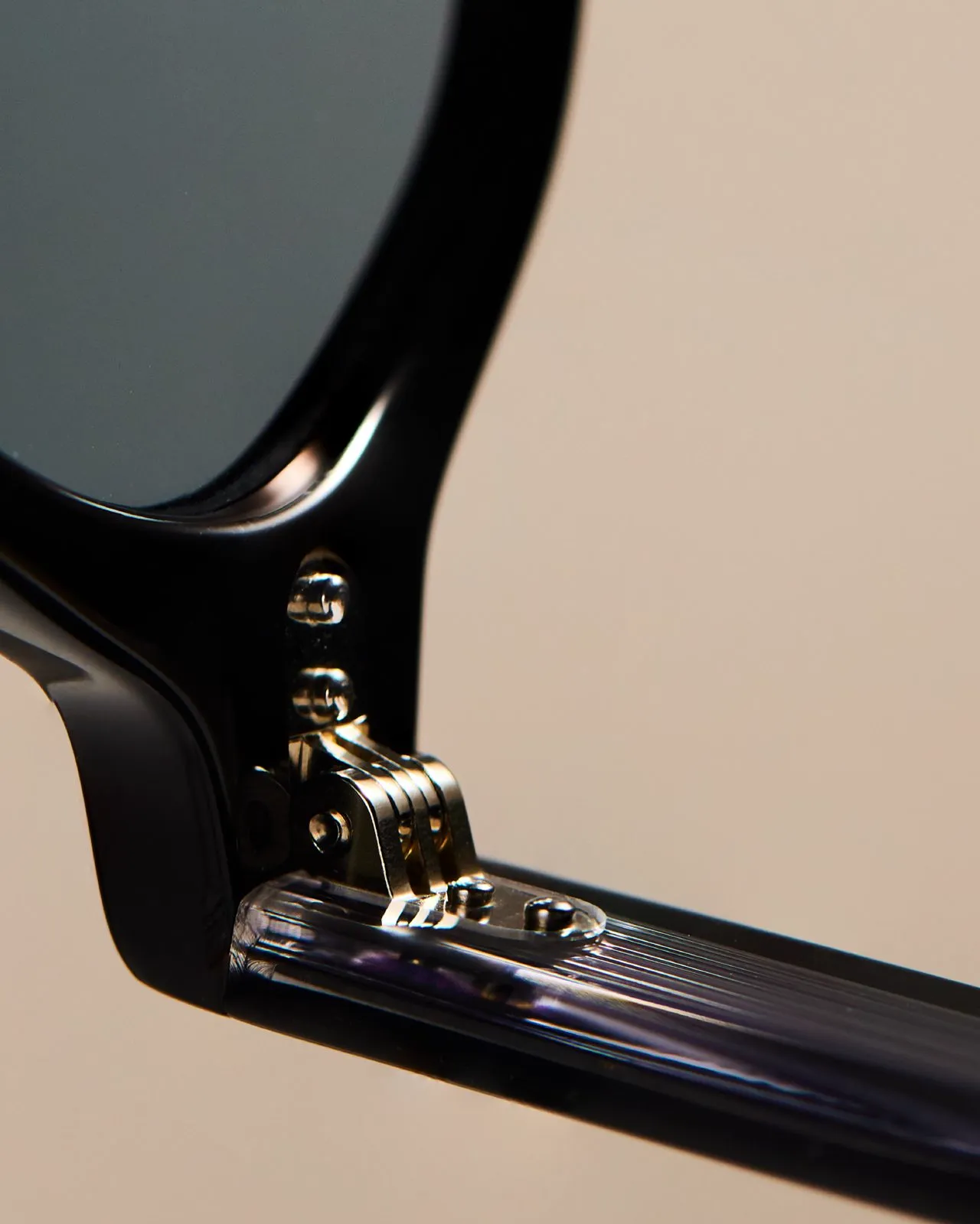 Gold hinge on a black acetate frame.